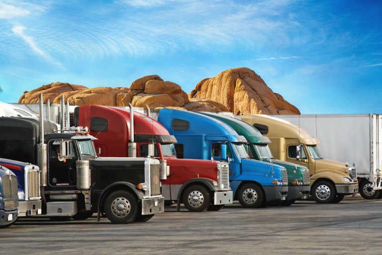 Multi-colored trucks parked in a row.